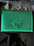 A green Prada card holder with a rhinestone-embellished surface and a silver-tone chain, presented in its original dark box. 